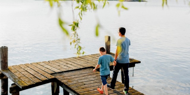 Man and boy approaching a lakeside fishing pier